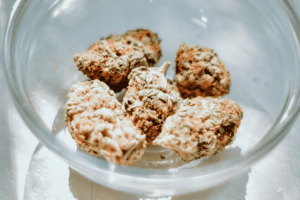 A clear glass bowl holds a handful of Durban Poison strain cannabis buds.