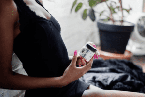 A woman hold a jar of Botany Farms CBD gummies for performance anxiety.