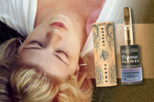 Lady in white dress peacefully lying with closed eyes, next to Organic Flower, Pine Walker, Indica cannabis vapor cartridge