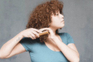 A woman combs her hair.