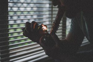 A man smokes cannabis from a glass bubbler.
