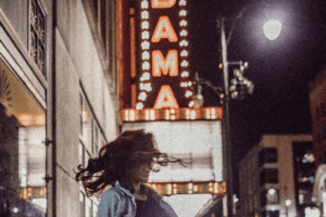 A blurry image of a woman dancing in front of a theater in Alabama.
