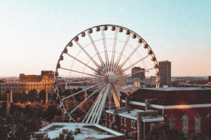 Ferris wheel in Georgia's skyline amidst buildings on a sunny day