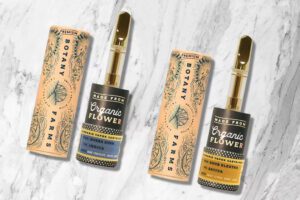 A couple of THC-free HHC tincture bottles from Botany Farms are displayed against a marble backdrop.