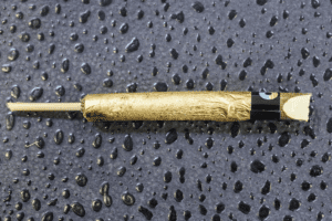 A cannagar sits on a flat surface among water droplets
